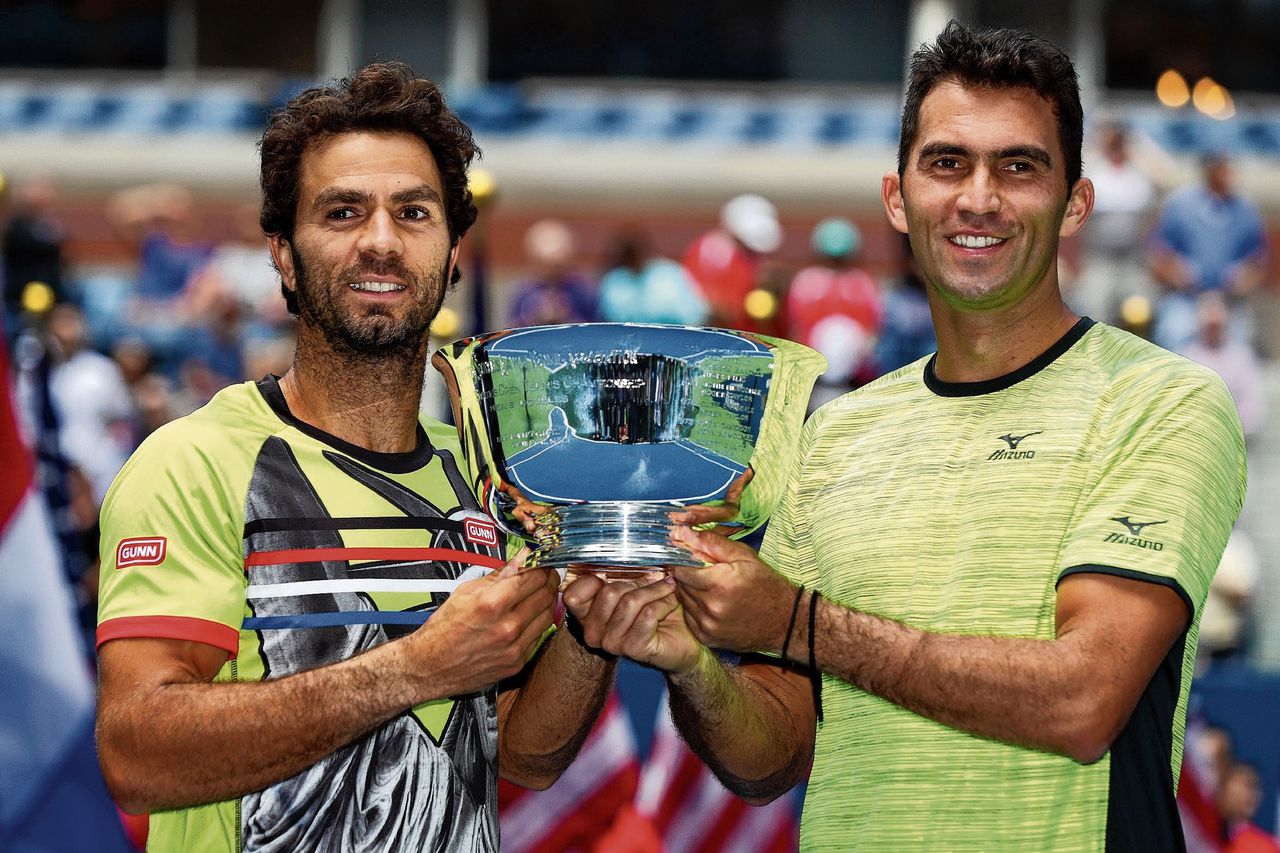 Jean-Julien Rojer (links) en Horia Tecau met de trofee na hun overwinning op het Spaanse duo Feliciano López/Marc López in de finale van de US Open.