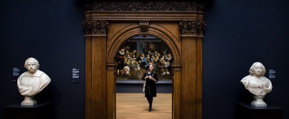 Een bezoeker bekijkt een schilderij in het Rijksmuseum.