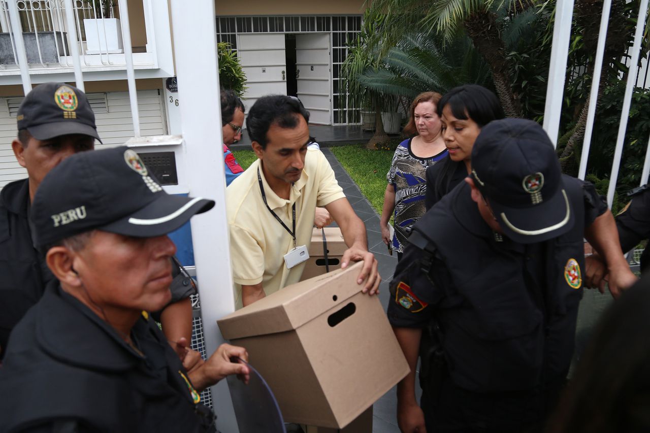 De belastingdienst haalt onder politiebewaking stukken uit het kantoor in Lima.