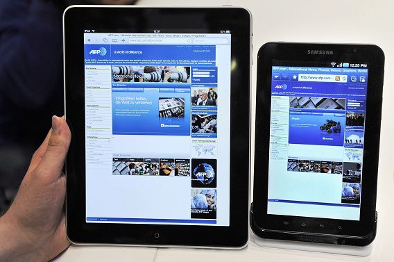 TO GO WITH AFP STORY BY GLENN CHAPMAN (FILES) A file photo taken on September 2, 2010 shows a woman holding an Apple iPad (L) next to a Samsung Galaxy Tab during the 50th International consumer electronics fair.Tablet computers and electronic readers promise to eventually close the book on the ink-and-paper era as they transform the way people browse magazines, check news or lose themselves in novels.AFP PHOTO / ODD ANDERSEN