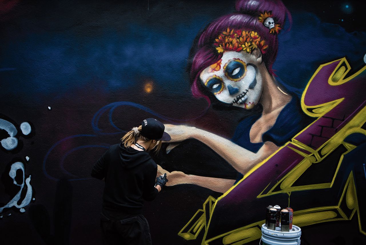 In het historische centrum van Mexico-Stad werkt een kunstenaar aan zijn muurschildering.