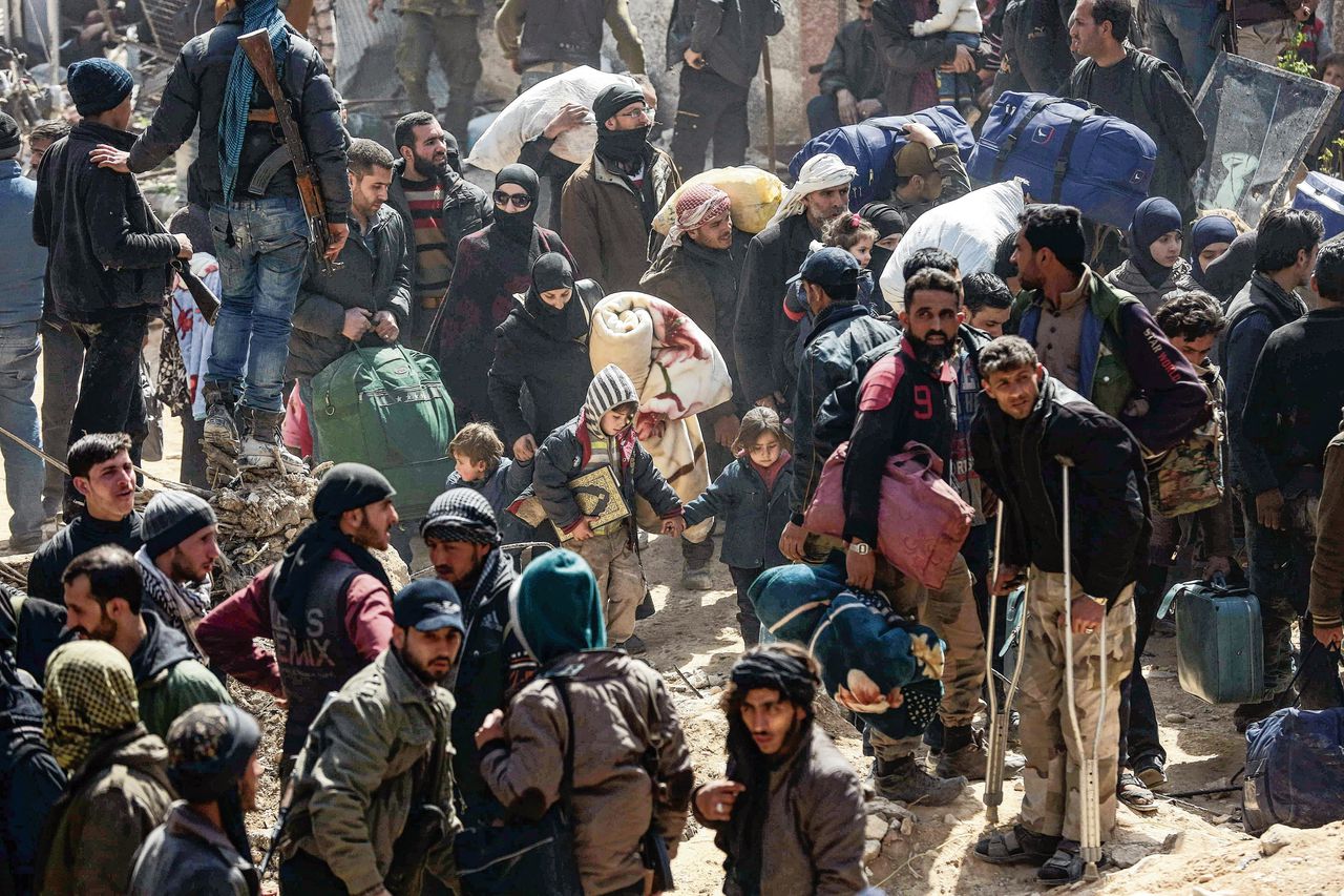 Links: Syrische burgers en strijders voor hun evacuatie uit Oost-Ghouta. Rechts: geëvacueerde kinderen na aankomst in het dorp Qalaat al-Madiq.
