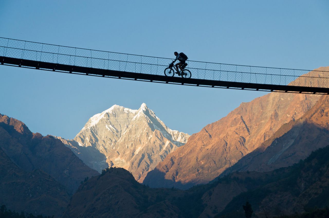 Een fietser steekt de Kali gandaki-vallei in Nepal over.