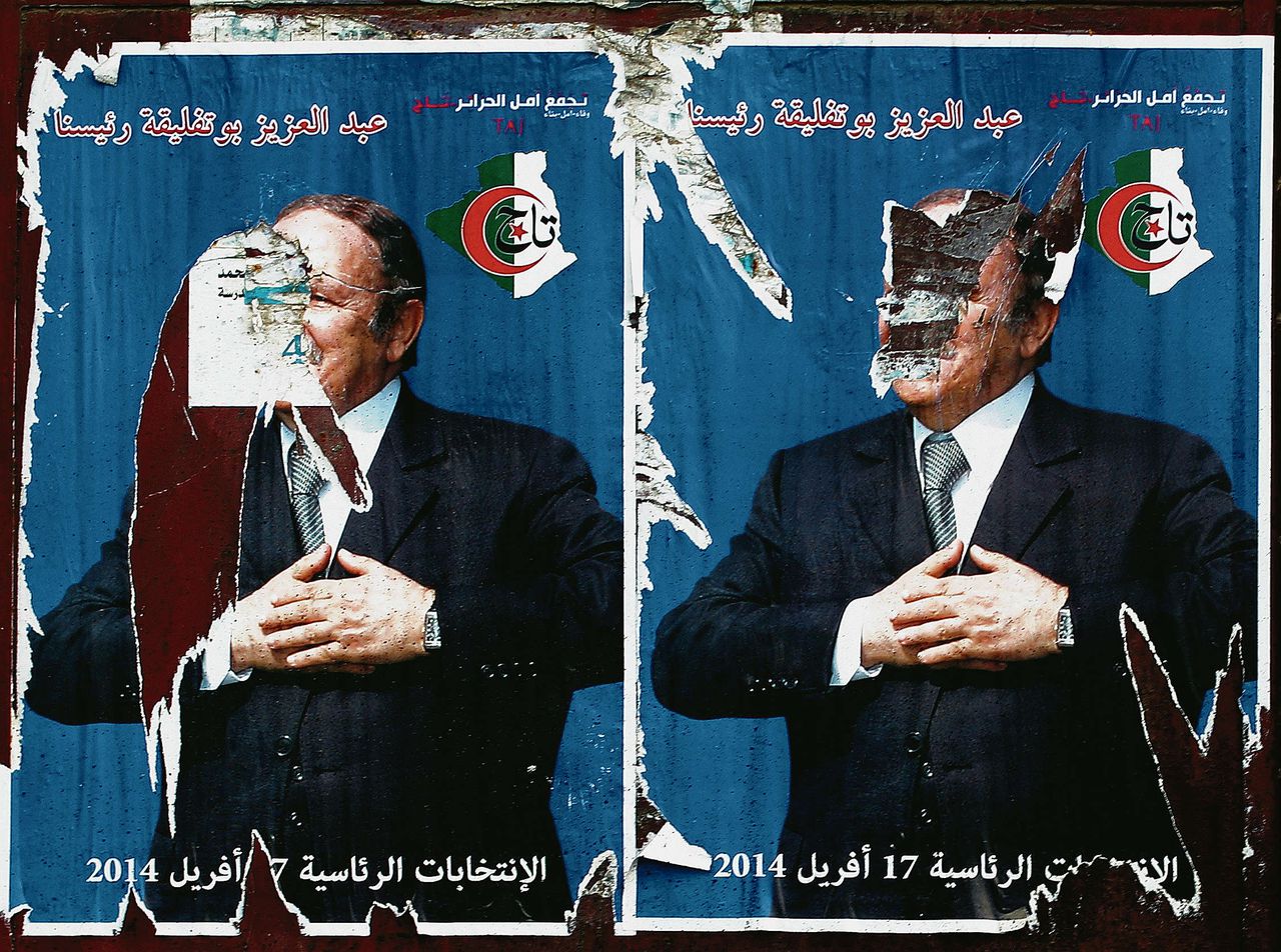 Beschadigde posters van de Algerijnse president Abdelaziz Bouteflika, die weer herkozen wil worden.