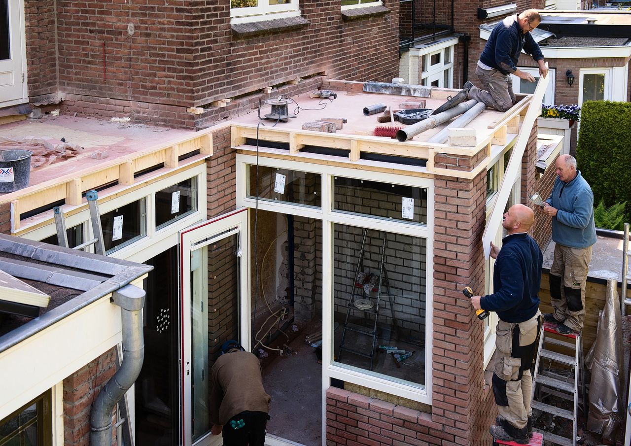 Bouwvakkers werken aan een uitbouw van een jarentwintigwoning in Nijmegen.