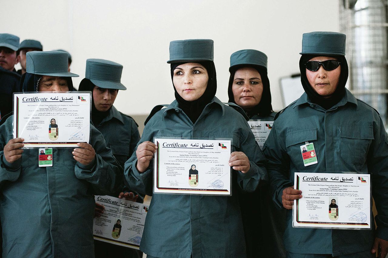 Politieagenten poseren in Kunduz met hun diploma, waarvoor ze werden getraind door Nederlandse marechaussees. Bij de politie in Kunduz werken nu 32 vrouwen.