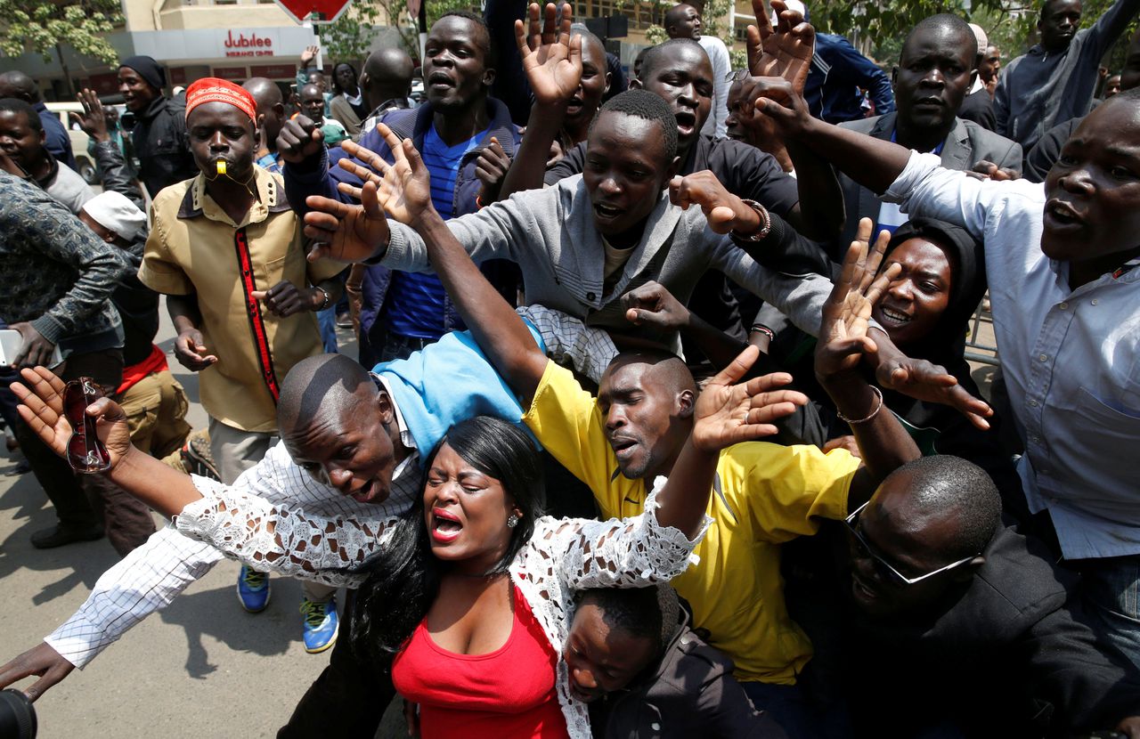Aanhangers van oppositieleider Raila Odinga juichen buiten de rechtszaal als ze horen dat de verkiezingen over moeten.