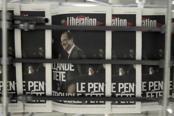 Copies of the French daily newspaper Liberation which announces "Hollande Leads. Le Pen Killjoy" on its front page after early results in the first round vote of the 2012 French presidential election are seen at their printing works in La Courneuve near Paris, late April 22, 2012. Far-rightist Marine Le Pen threw France's presidential race wide open on Sunday by scoring nearly 20 percent in the first round - votes that may determine the outcome of the May 6 runoff between Socialist favourite Francois Hollande and conservative President Nicolas Sarkozy. REUTERS/Charles Platiau (FRANCE - Tags: POLITICS ELECTIONS MEDIA)