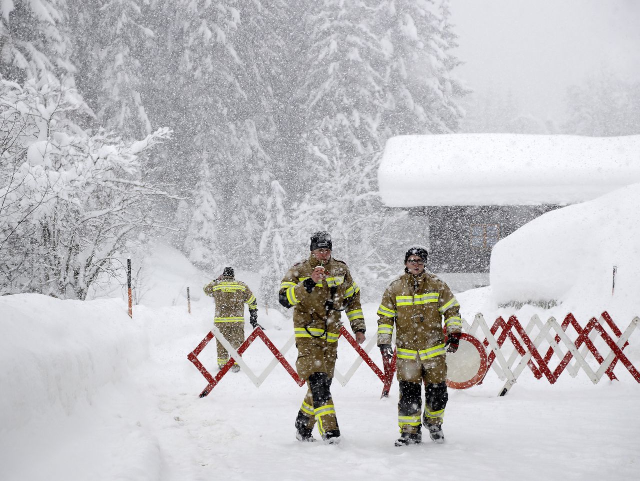Brandweerlieden sluiten bij het Oostenrijkse bergdorp Filzmoos een weg af, omdat die onbegaanbaar is geworden door de sneeuw.