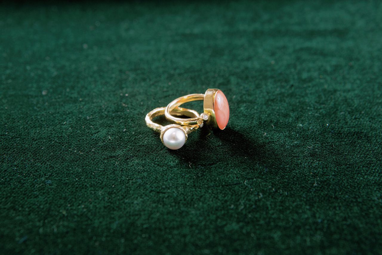 Parel uit oorhangers verwerkt in een gebeeldhouwde geelgouden ring, en bloedkoraal uit een broche verwerkt in een ring met diamantjes.