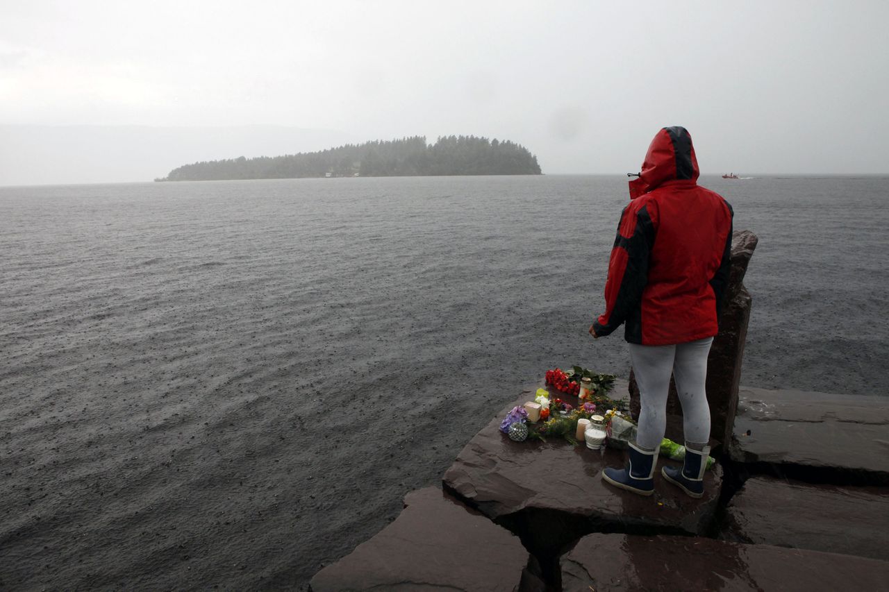 A woman stands on the shore in front of Utoeya island, northwest of Oslo, July 24, 2011. At least 92 people are dead after a gunman dressed in police uniform opened fire at a youth camp of Norway's ruling political party on Friday in Utoeya island, hours after a bomb blast in the government district in the capital Oslo. According to local media, four or five participants at the youth camp are still unaccounted for. REUTERS/Fabrizio Bensch (NORWAY - Tags: CIVIL UNREST CRIME LAW)