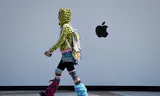 Een vrouw loopt langs een winkel van Apple in Beijing. 90 procent van de iPhones wordt in China geassembleerd. Foto Wang Zhao/AFP