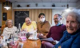 Bewoners van het tehuis samen met de directeur en een medewerker. 
