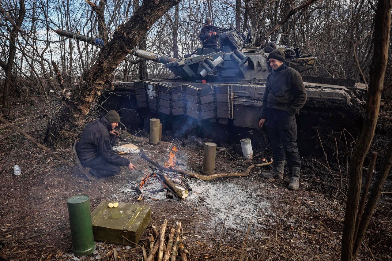 Oekraïense soldaten warmen zich aan een vuurtje bij Bachmoet, afgelopen woensdag.