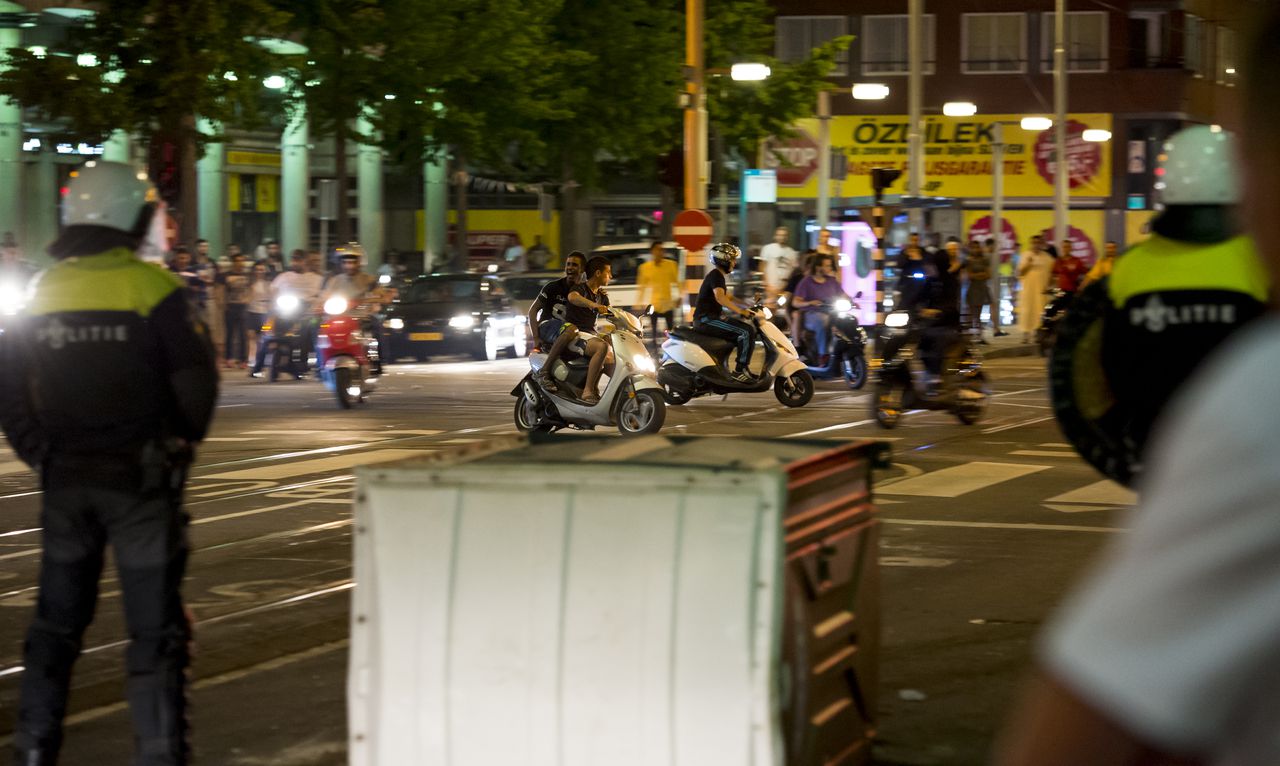 Agenten en leden van de Mobiele Eenheid (ME) op straat in de Haagse Schilderswijk waar rellen uitbraken.