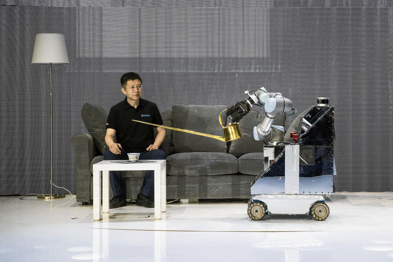 Een AI-robot van het bedrijf Baidu probeert een kopje thee in te schenken, afgelopen juli in Beijing.