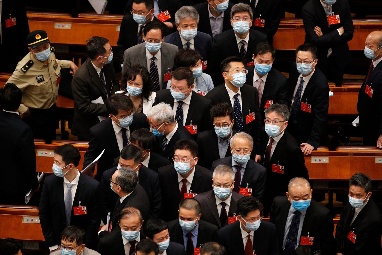 Bij de opening van het Volkscongres dragen de aanwezigen mondmaskers ter bescherming tegen Covid-19.
