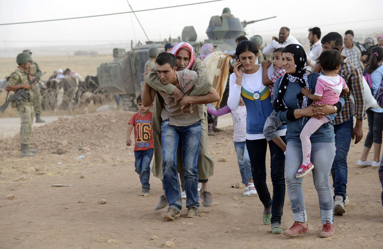 Syrische Koerden steken de Syrisch-Turkse grens over.