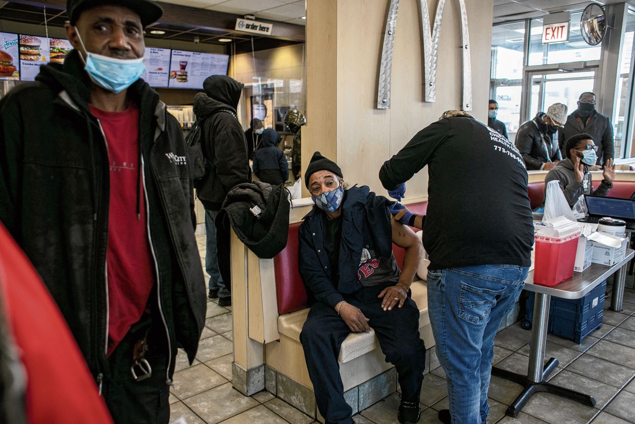 Een man krijgt in december een boosterprik tegen het coronavirus in een McDonald’s in Chicago.