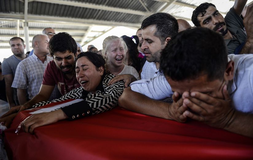 Nabestaanden rouwen bij de kisten van de slachtoffers van de zelfmoordaanslag in Suruç.