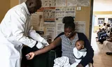 Een laborant in een ziekenhuis in Kisumu, Kenia, neemt bloed af bij een hiv-positieve moeder. De hiv-zorg in Kenia dreigt in te storten door de ontmanteling van USAID.