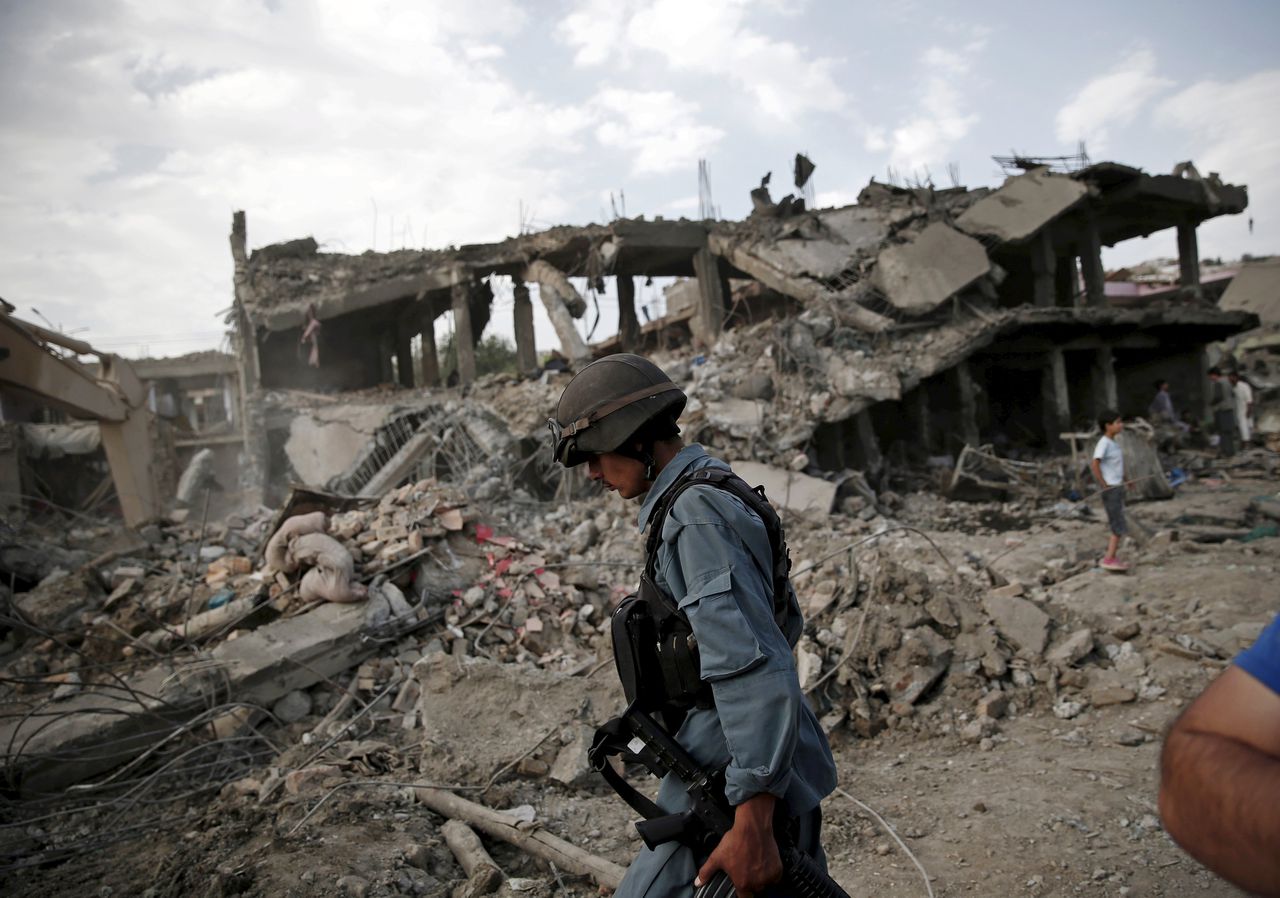 Een Afghaanse politieman in de omgeving van de eerste explosie van vandaag in Kabul, waarbij zeker vijftien mensen om het leven kwamen.