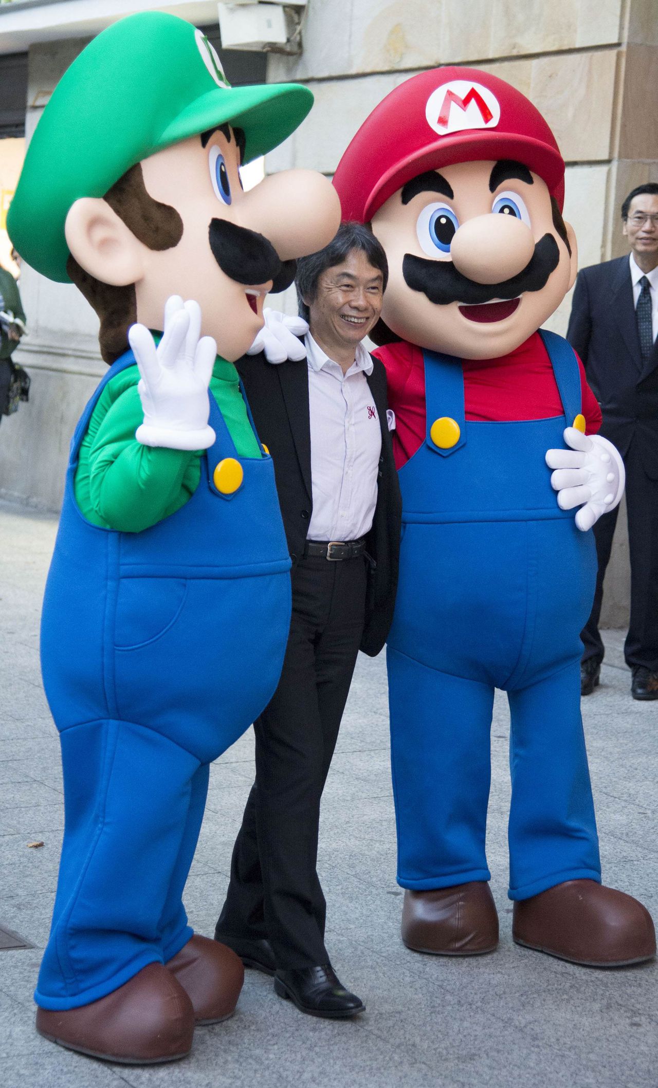 Japanese video game Designer Shigeru Miyamoto poses with men dressed as Mario Bros characters during a tribute in Gijon, October 25, 2012. Miyamoto will be awarded the 2012 Prince of Asturias Award for Communication and Humanities. The Prince of Asturias Awards are held annually since 1981 to reward scientific, technical, cultural, social and humanitarian work done by individuals, work teams and institutions. REUTERS/Felix Ordonez (SPAIN - Tags: ENTERTAINMENT SOCIETY)