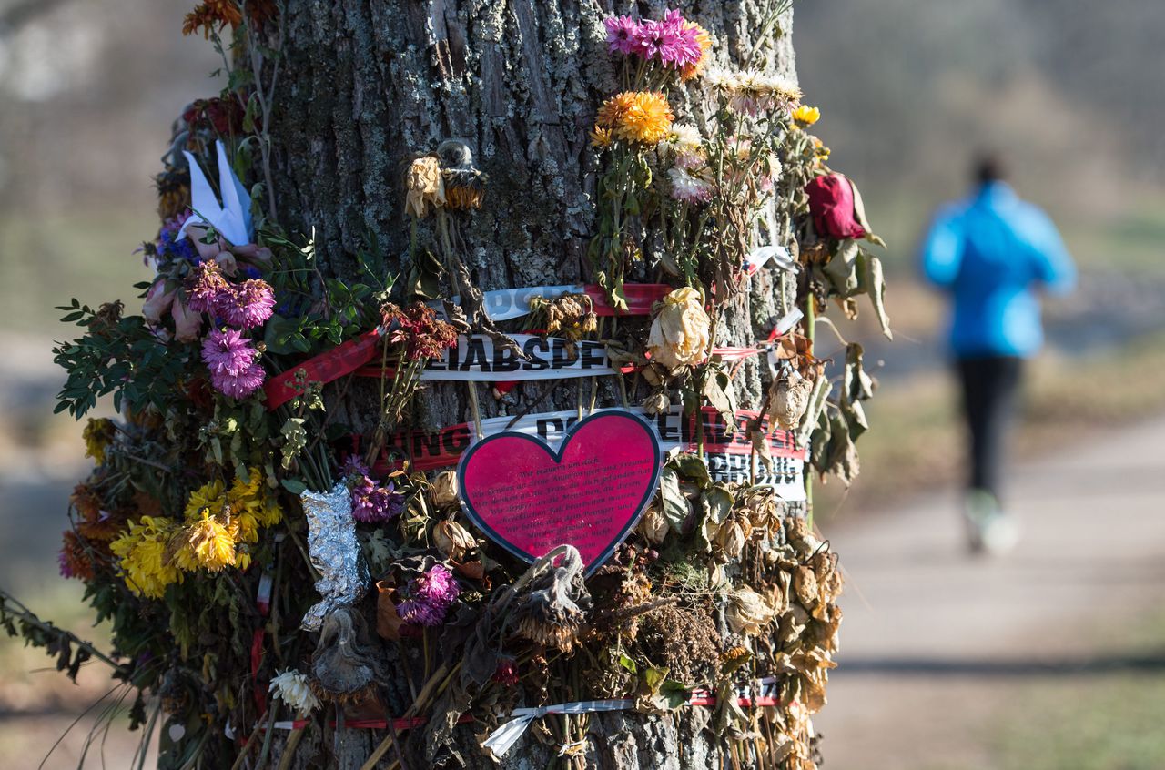 Bloemen zijn rondom een boom gehangen op de plek waar de 19-jarige vrouw in Freiburg werd gevonden.