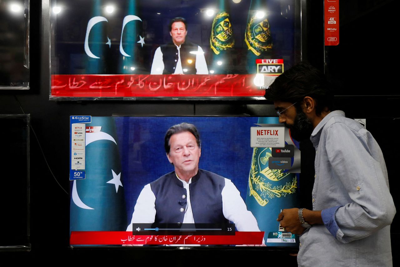 Een winkeleigenaar in Islamabad bekijkt eind maart een toespraak van Khan op televisie.
