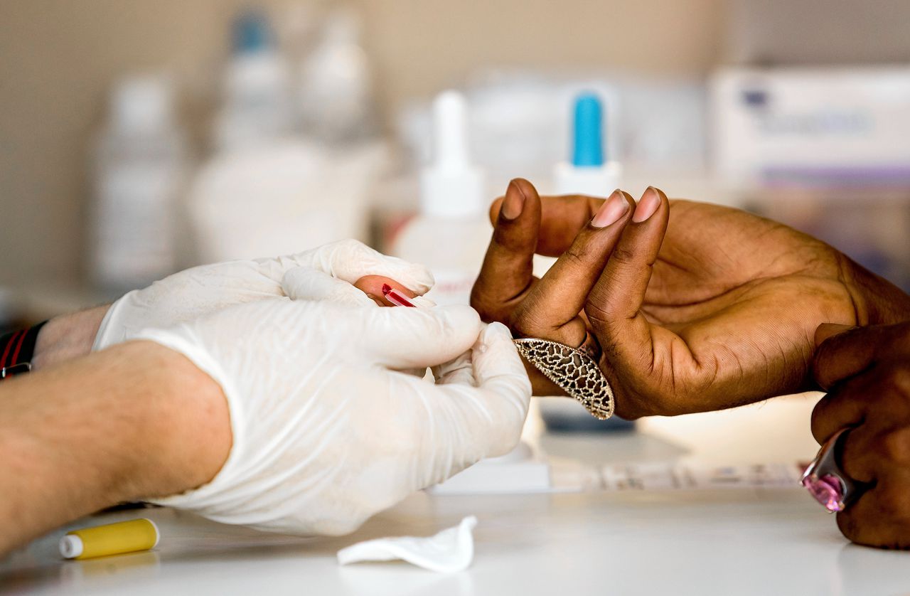 Een medewerker van de wereldwijde Aids Healthcare Foundationneemt een hiv-test af in Amsterdam.