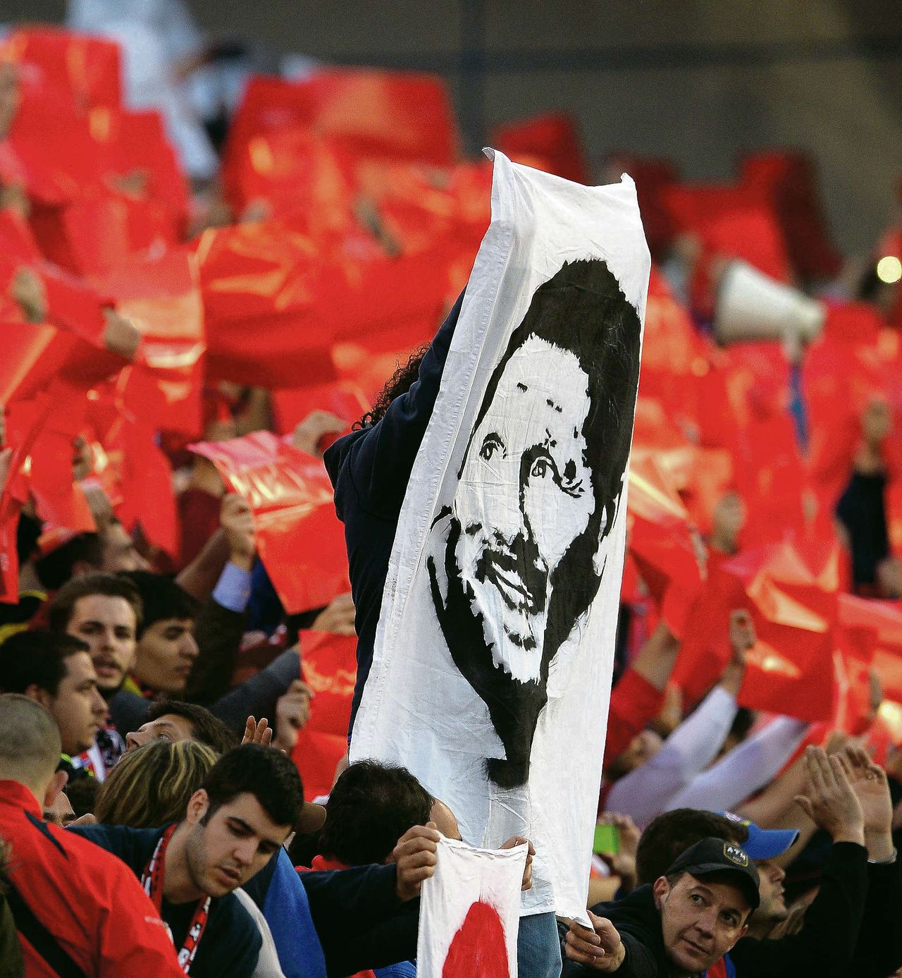 Fans van Atlético Madrid met een spandoek van coach Diego Simeone.