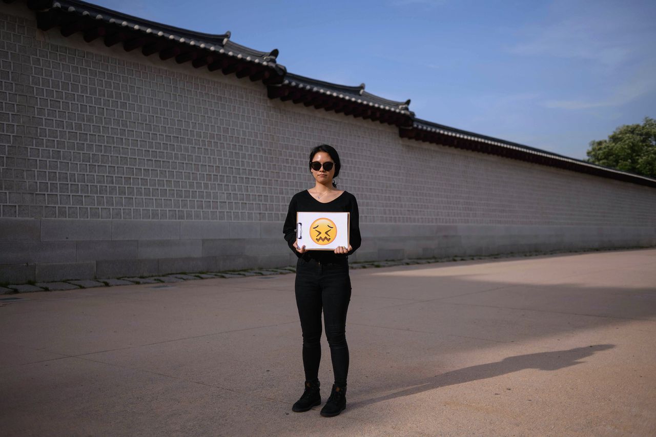 Jung Hye-mi (29), in Seoul, toont met een emoji hoe ze zich voelt nadat de Amerikaanse president Trump de top met de Noord-Koreaanse leider Kim Jong-Un heeft afgezegd.