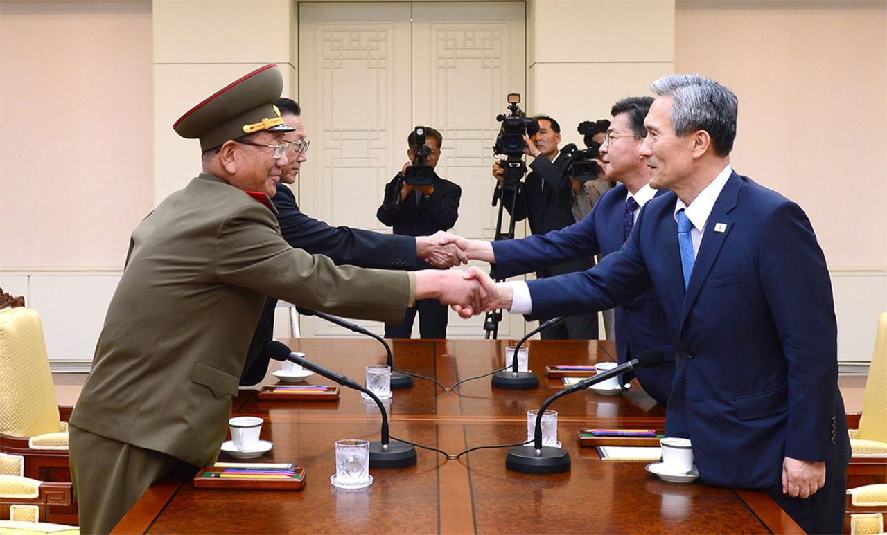 De delegaties van Noord- en Zuid-Korea schudden elkaar de hand.