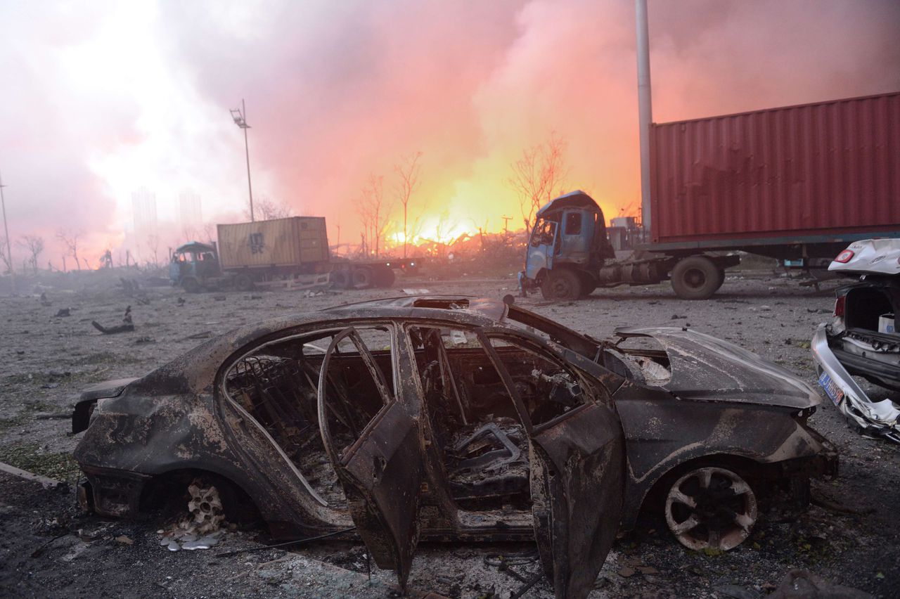 Een vernietigde auto na de explosies op het industrieterrein in Tianjin.