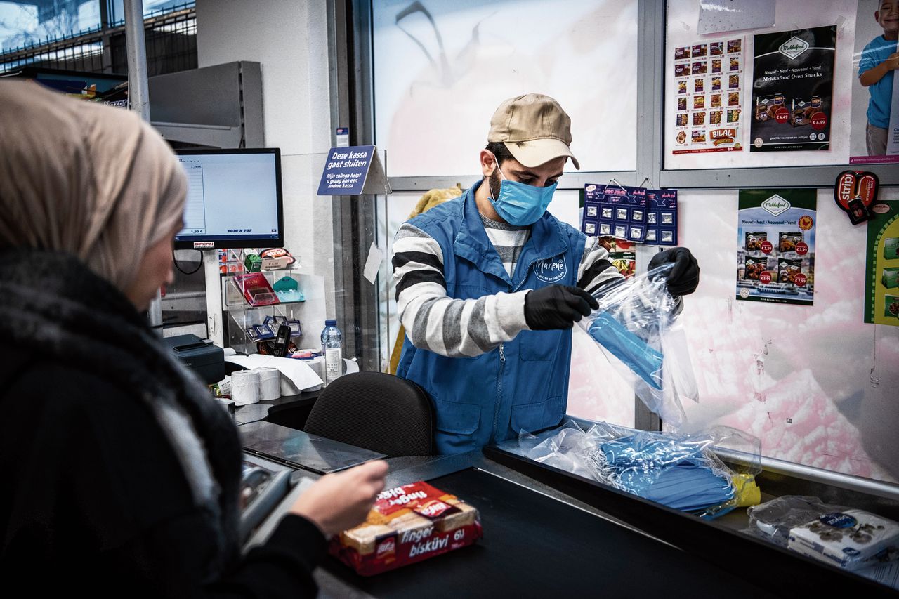 Een supermarkt in Groningen is nog open: wel draagt de kassamedewerker een mondkapje en handschoenen.