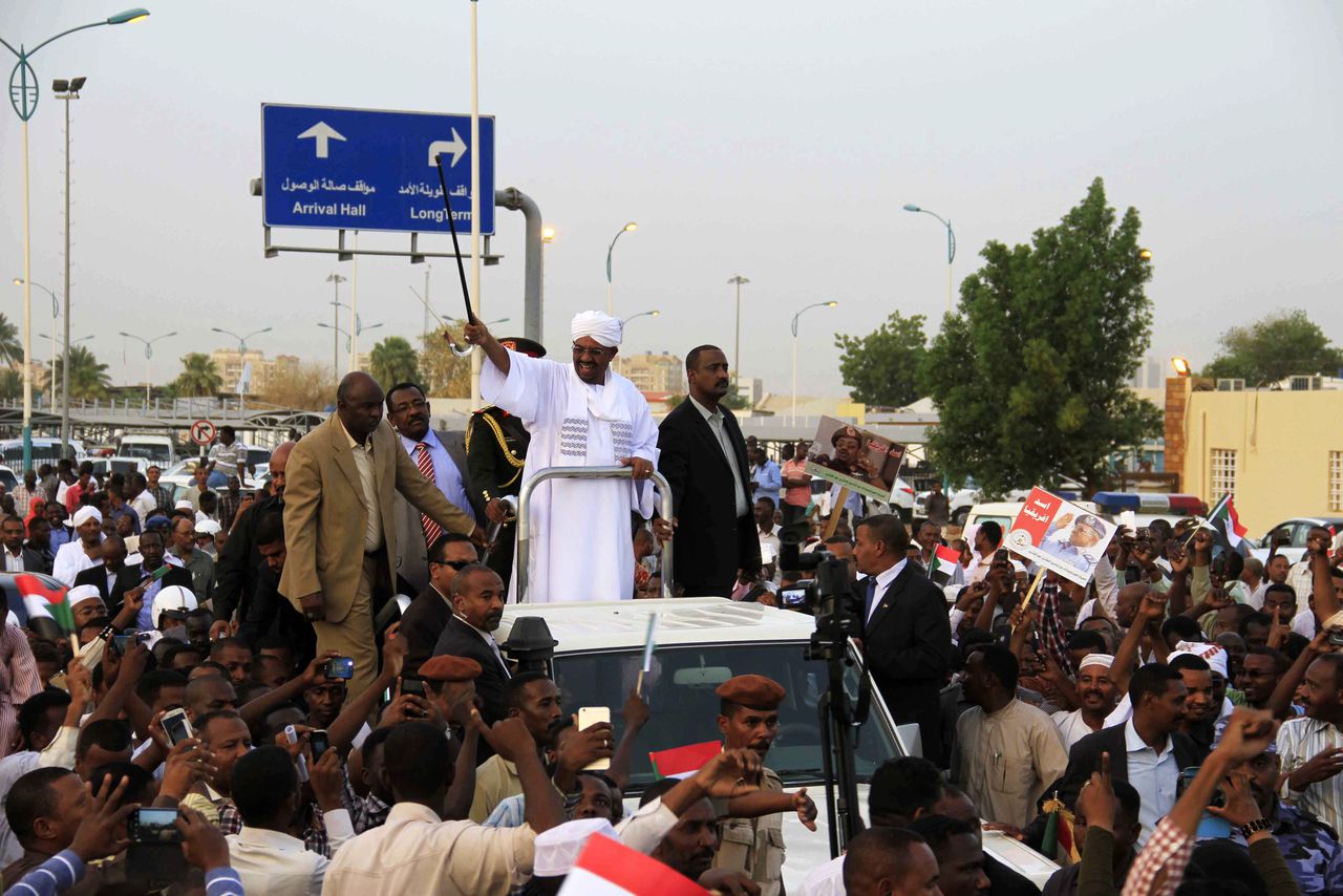 Omar al-Bashir (midden), president van Soedan, omringd door zijn aanhangers.