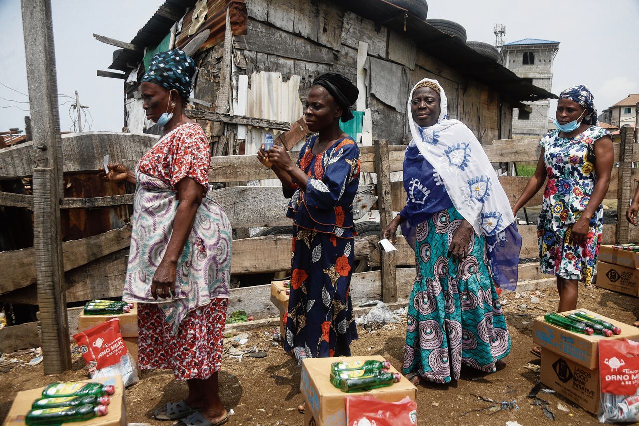 Bewoners van de sloppenwijk Oworonshokiin Lagos, Nigeria, in de rij voor voedselpaketten van een lokale organisatie.