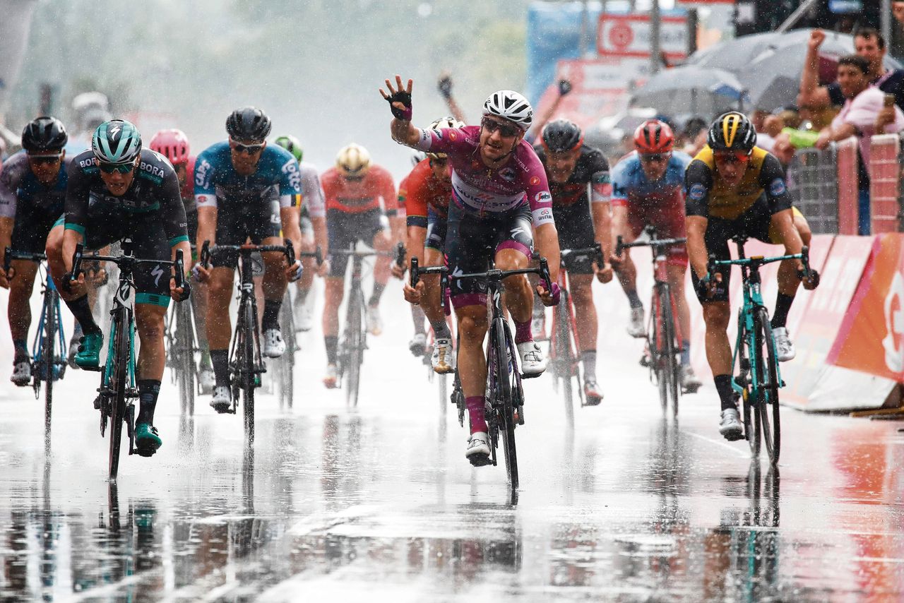 Danny van Poppel (rechts) komt tekort in de eindsprint tegen de Italiaanse sprinter Elia Viviani, die zijn vierde ritzege in de Giro viert met vier vingers in de lucht.