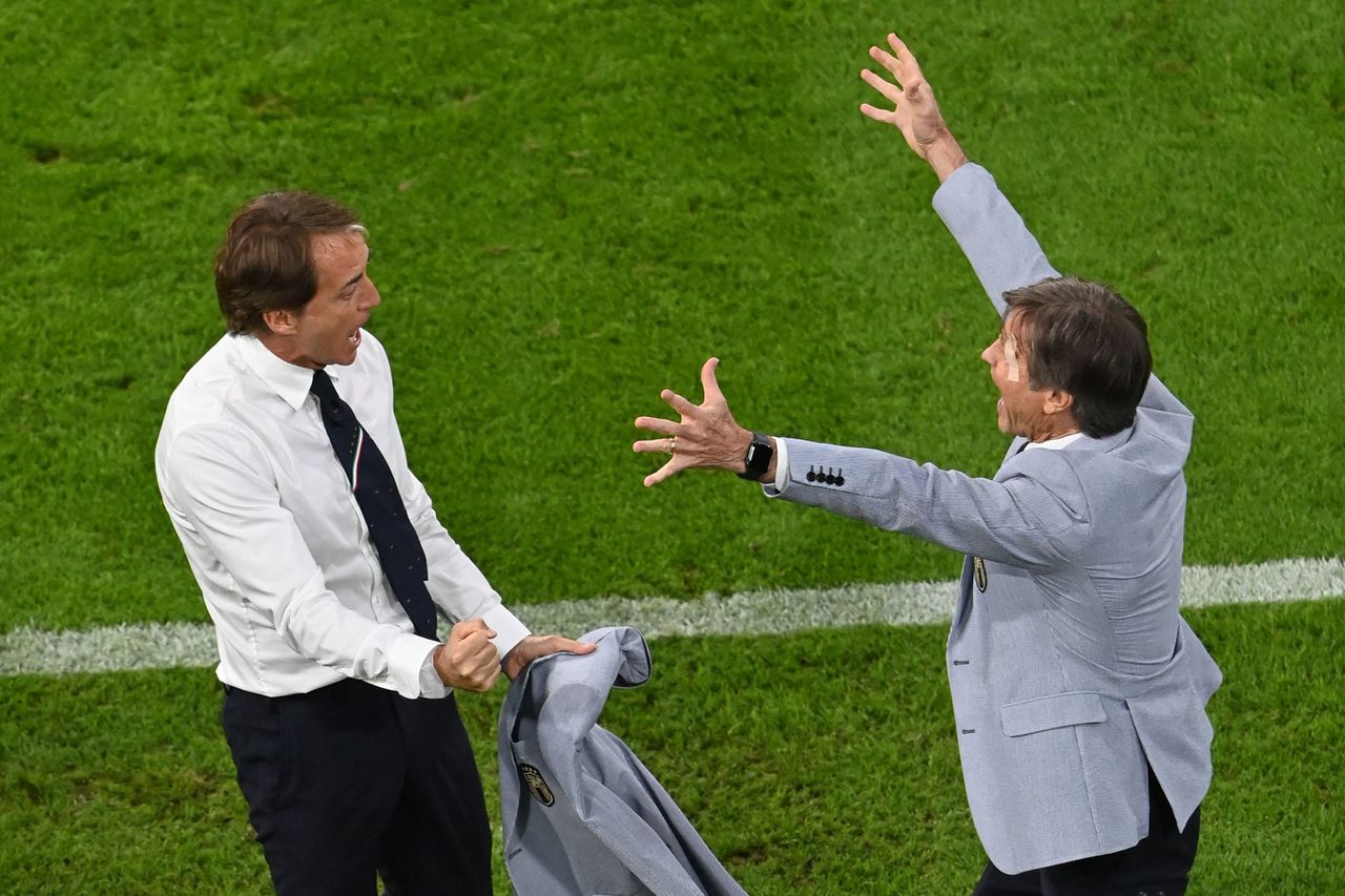 Het fluitsignaal klinkt: Roberto Mancini (links) viert de winst van Italië in de kwartfinales met een assistent.
