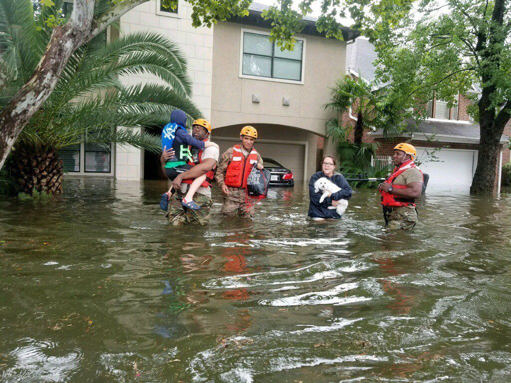 Reddingwerkers halen gestrande inwoners van Houston uit hun ondergelopen huis.