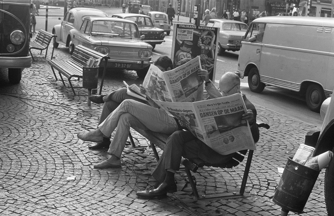 Amsterdam, 1969. De dag na de eerste maanlanding (die op 20 juli 1969 plaatsvond) lezen mensen de krant op straat.