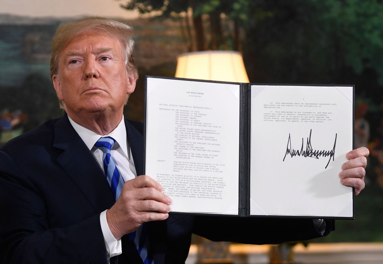 President Donald Trump toont dinsdag het zojuist gesigneerde document waarmee sancties tegen Iran opnieuw van kracht worden.