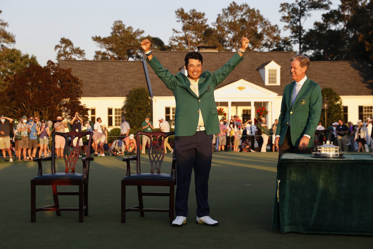De Japanse golfer Hideki Matsuyama in het groene jasje, de hoofdprijs bij de Masters. Rechts Fred Ridley, voorzitter van Augusta National Golf Club.