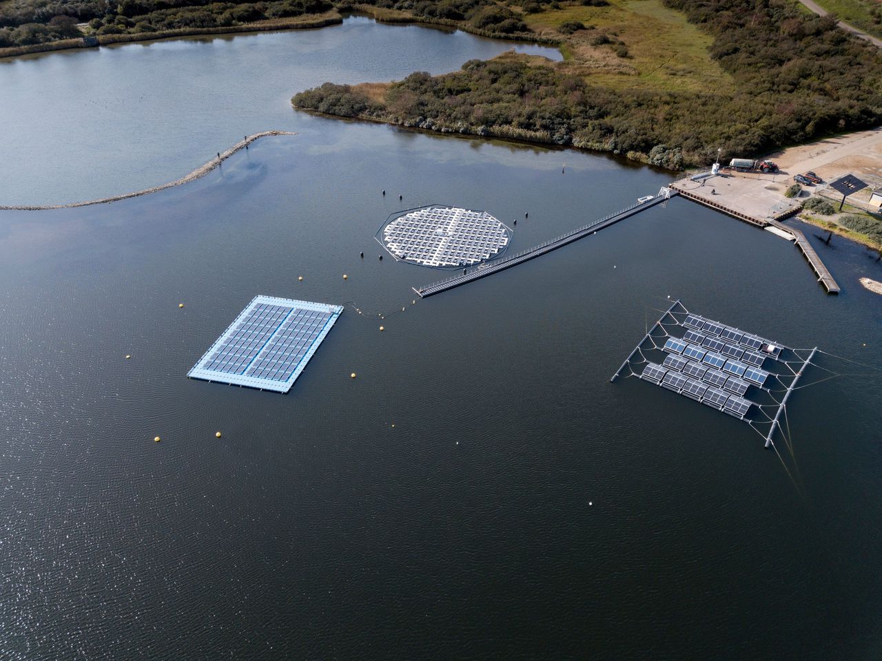 Op het Oostvoornse Meer test TNO drie constructies met drijvende zonnepanelen. Vanaf links: vrijwel platliggende panelen; rond eiland dat meedraait met de zon; panelen in dakjes tegen elkaar.
