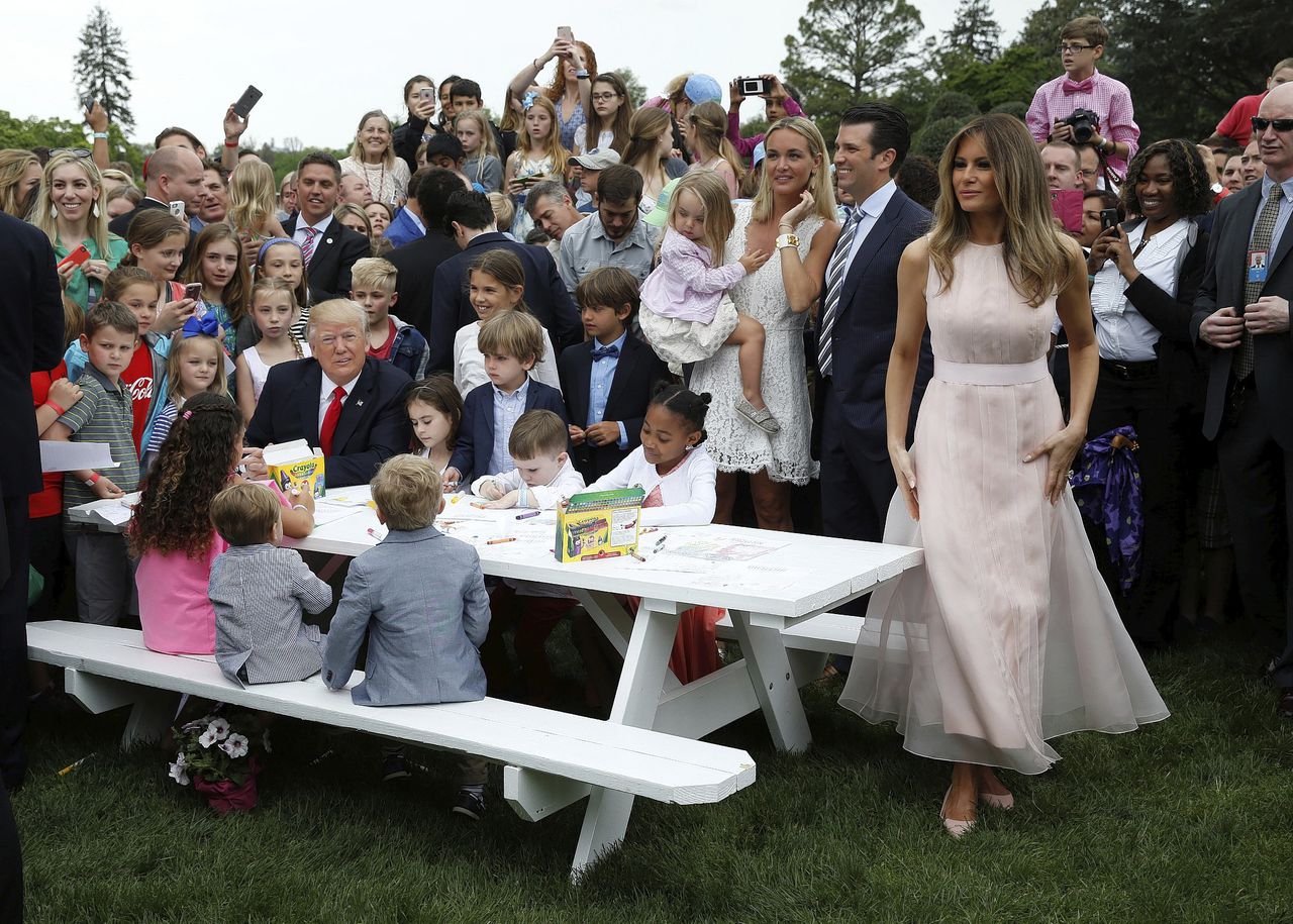 President Donald Trump (links aan tafel) en First Lady Melania Trump (rechts) maandag in de tuin van het Witte Huis bij het traditionele ‘eierrollen’.