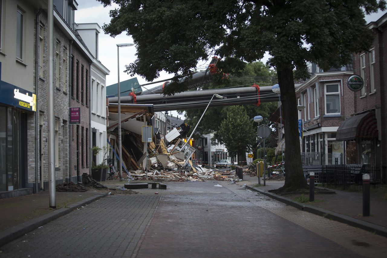 De Hooftstraat in Alphen aan den Rijn een dag na het ongeval. Op de achtergrond de ravage die werd aangericht door de twee bouwkranen.