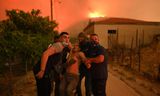 Vrijwilligers helpen een oude man tijdens een grote bosbrand bij de Griekse stad Alexandroupolis,  augustus 2023. Zuid-Europa zal als gevolg van klimaatverandering vaker worden getroffen door branden.