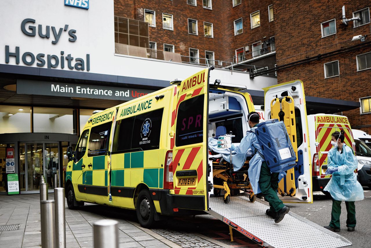 Een ambulance voor het Royal London Hospital. De combinatie van meer coronapatiënten en zorgpersoneel in quarantaine leidt tot veel problemen.