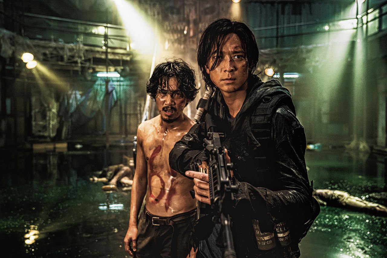 Jung-seok (Gang Dong-won, rechts) moet zich staande zien te houden tussen zombies en een rebelse groep die een stad in haar greep houdt, in ‘Peninsula’.