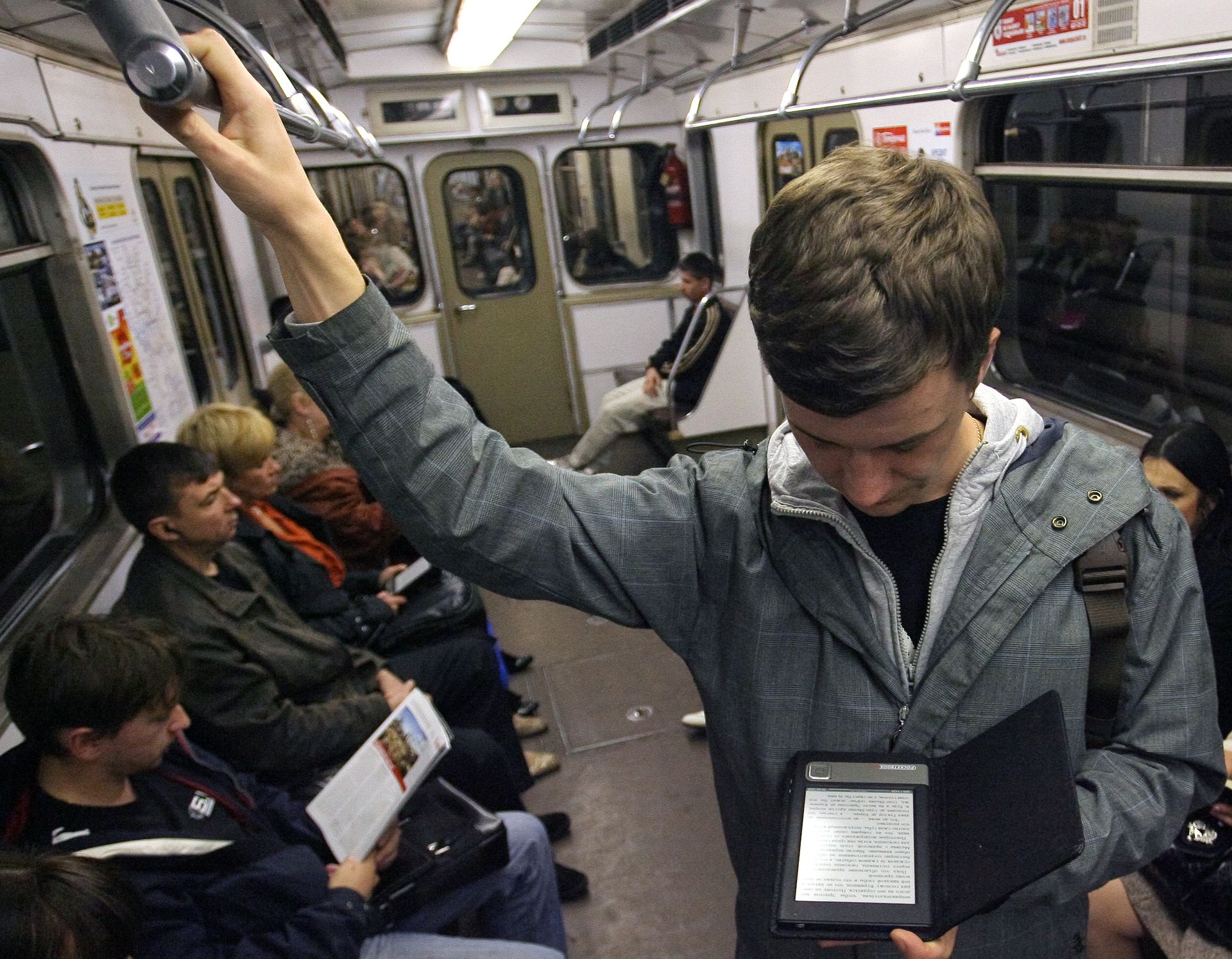 Она читает в метро. Человек с электронной книгой в метро. Мужик с телефоном в метро. Чтение в транспорте. Люди с книгами в метро.